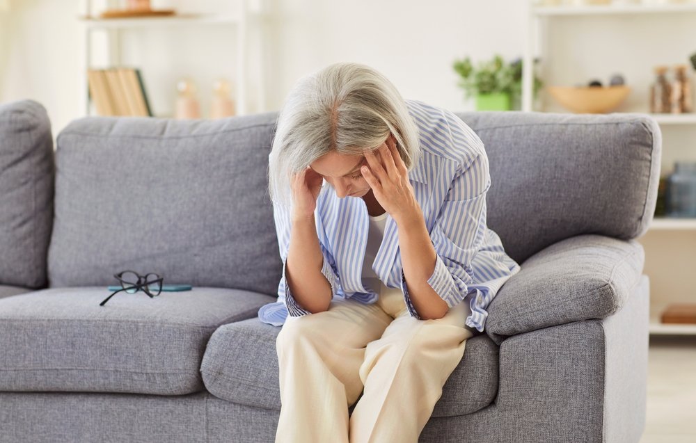 Adulta mayor, sentada y triste